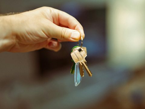 Persona sosteniendo las llaves de su nueva vivienda