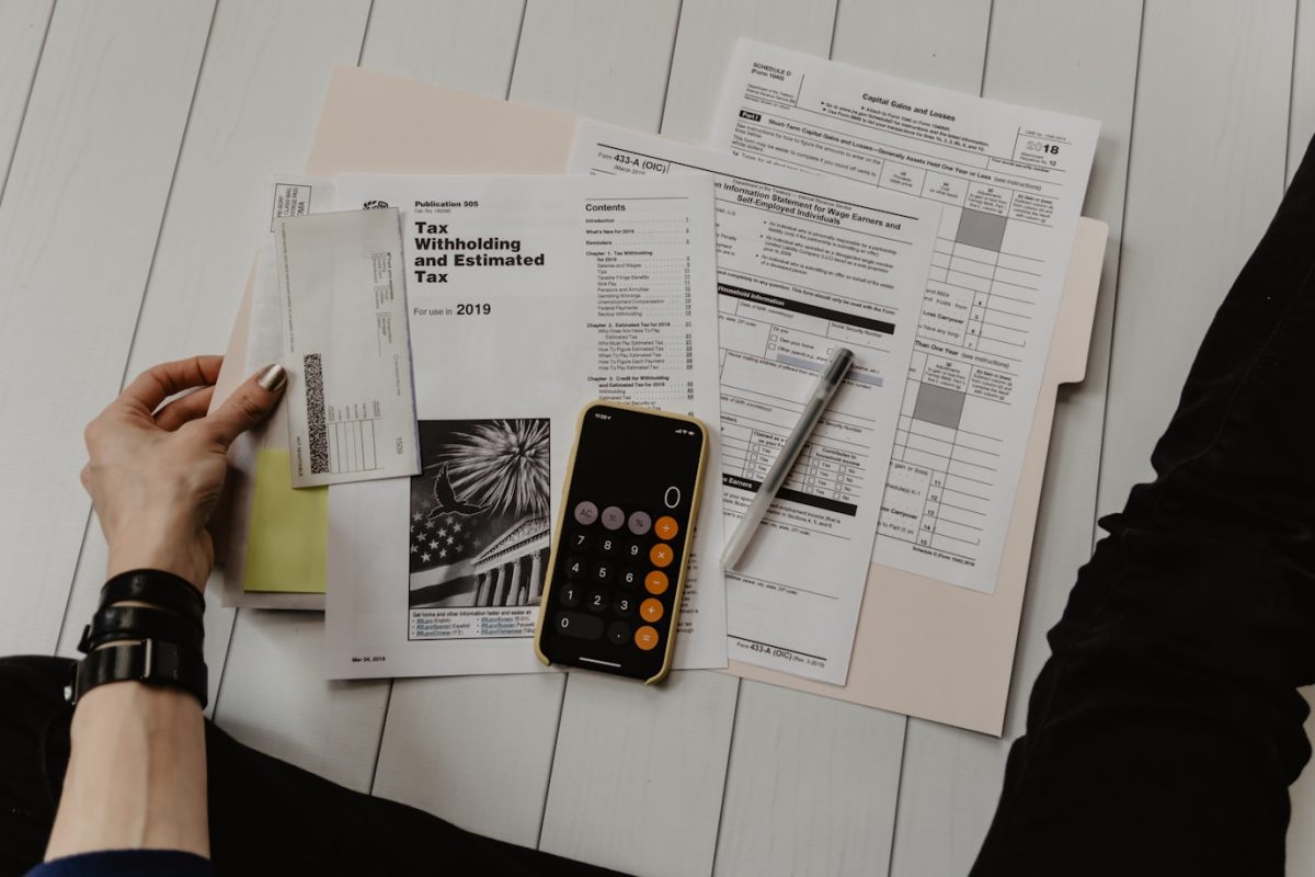Cálculo de contribuciones de bienes raíces con papeles y calculadora