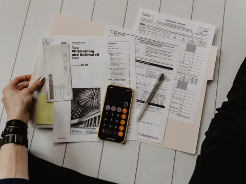 Cálculo de contribuciones de bienes raíces con papeles y calculadora