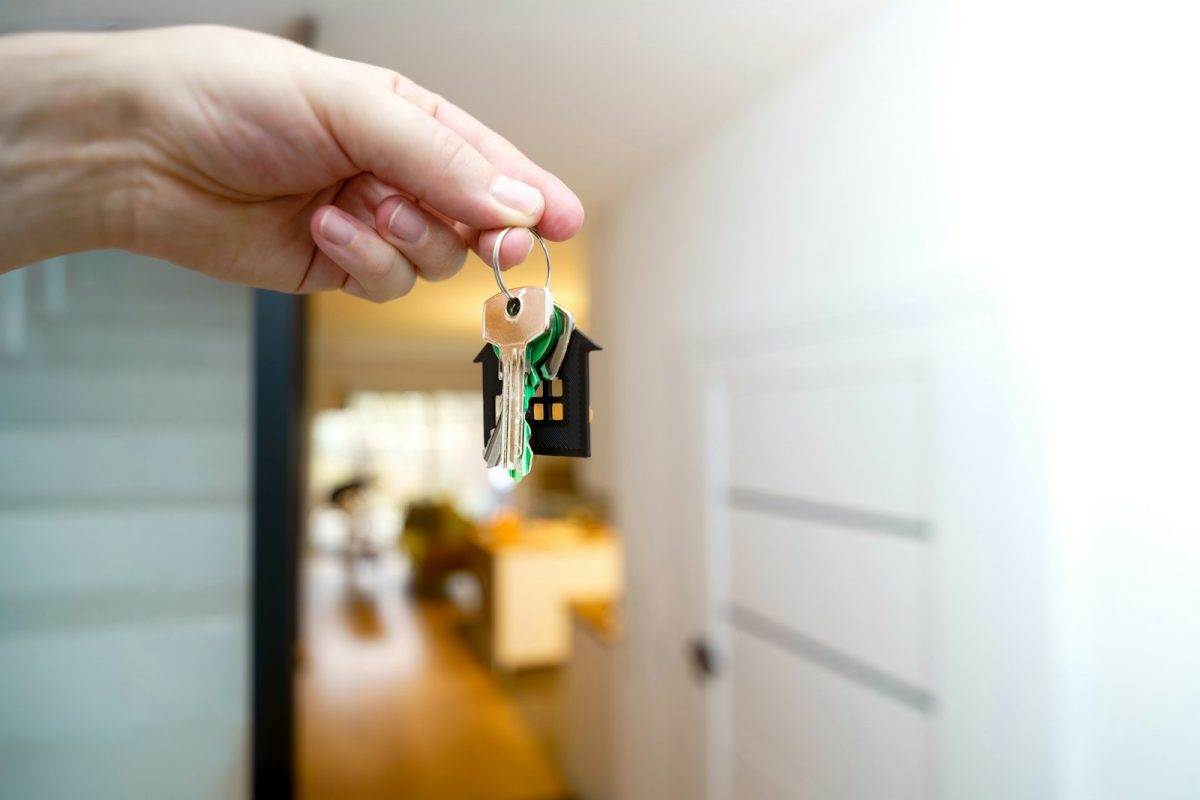 Manos sosteniendo las llaves de una casa nueva