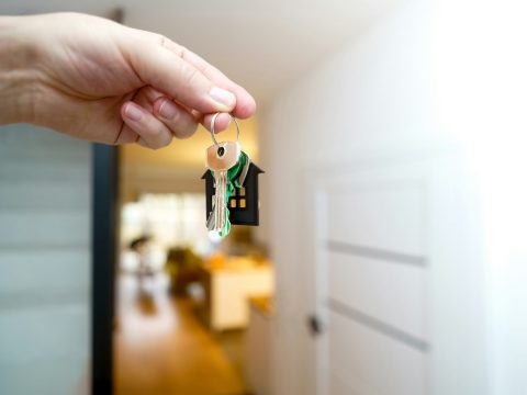 Manos sosteniendo las llaves de una casa nueva