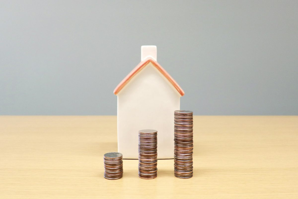 Maqueta de casa junto a monedas que representan el crédito hipotecario