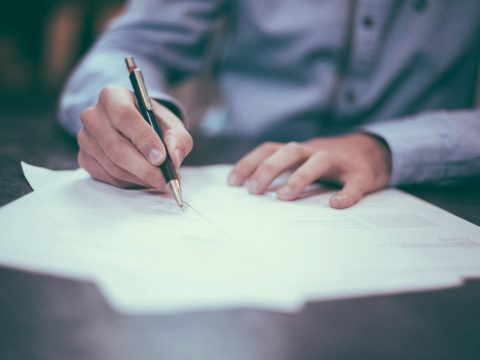 Persona firmando la contratación de un seguro