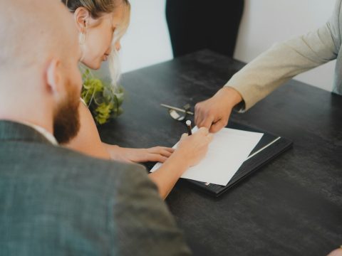 Pareja firmando los documentos de compra de una propiedad